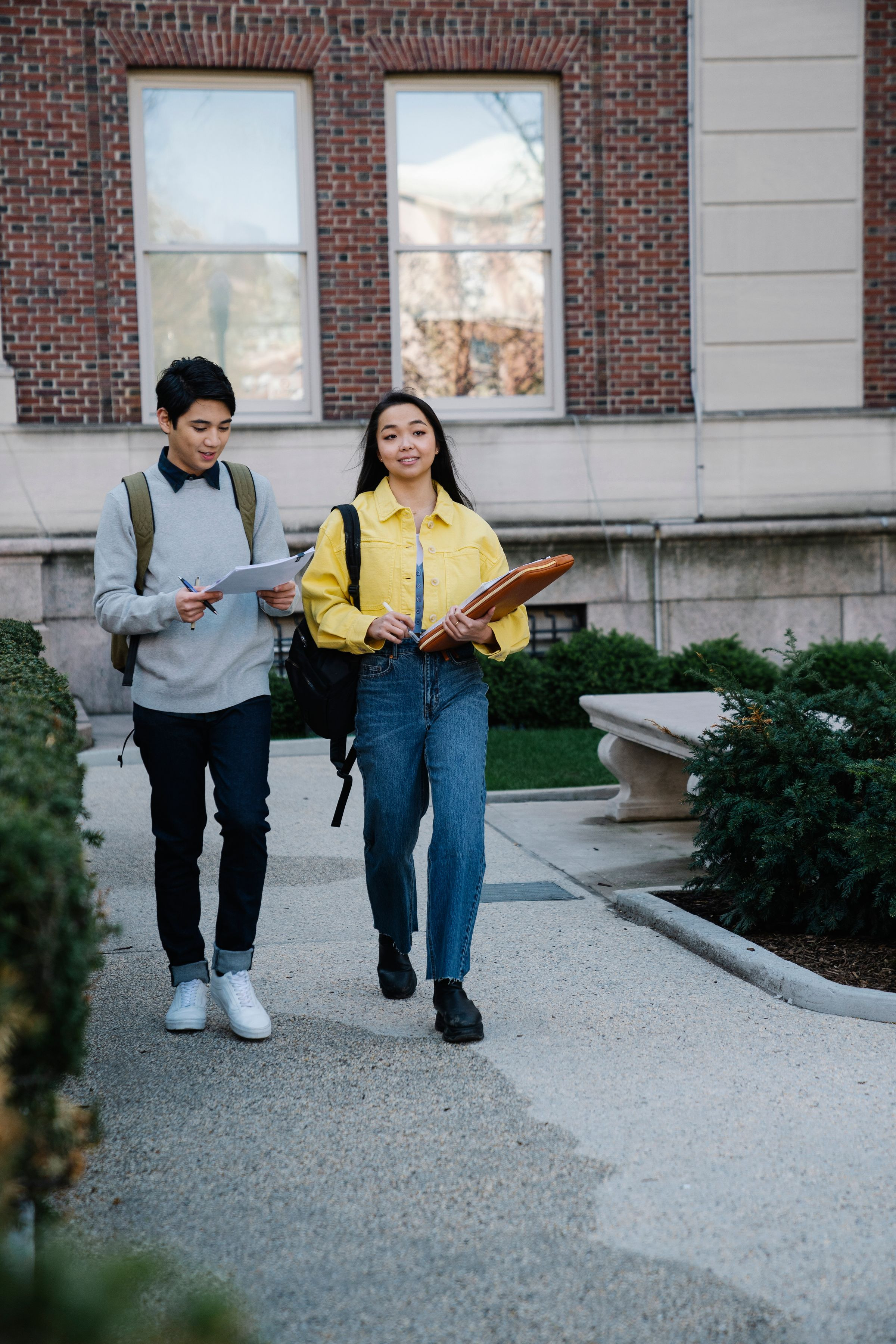 University students walking across campus with books